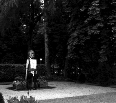 Två män framför Mästarens byst i parken nedanför Festspielhaus.